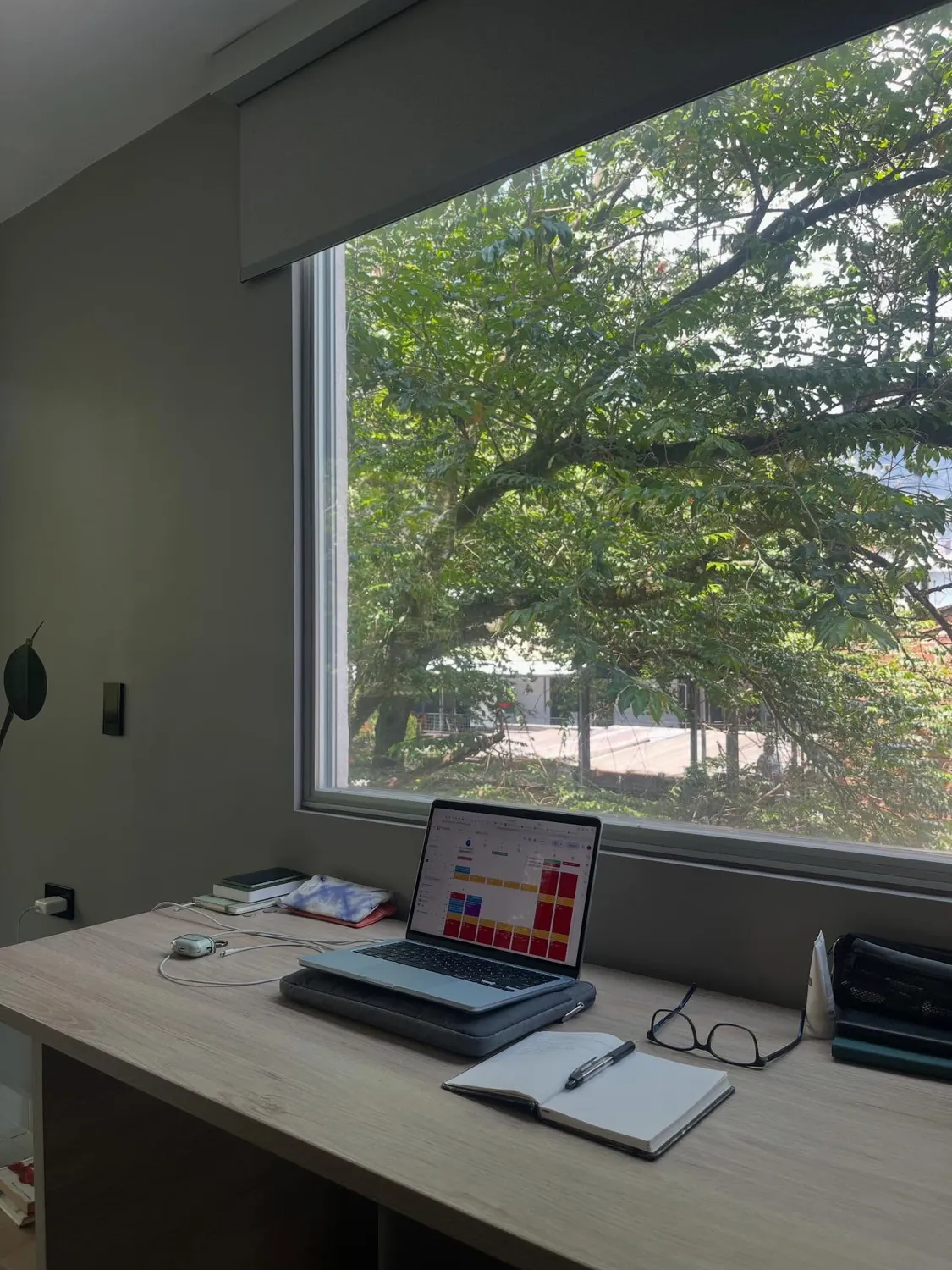 Escritorio frente a una ventana abierta sobre los árboles, en Medellín